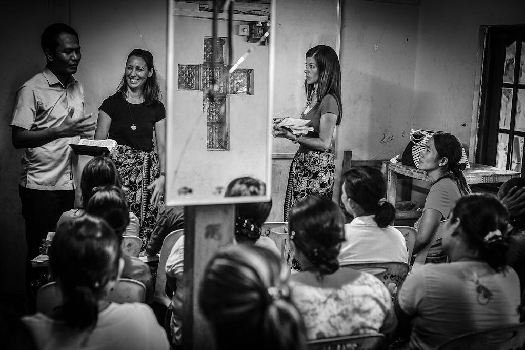 A diverse group of people gather in a room for an educational seminar.